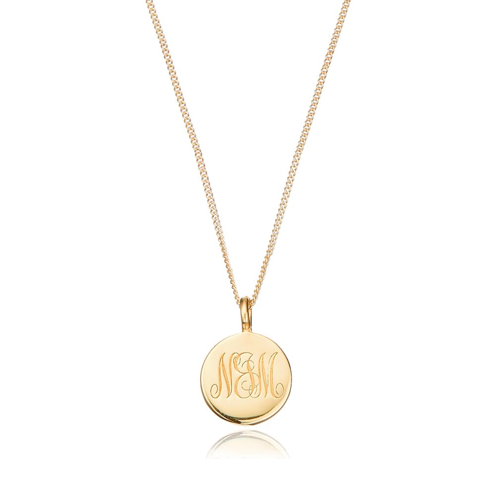 Gold large engraved disc necklace with N&M engraved on a white background