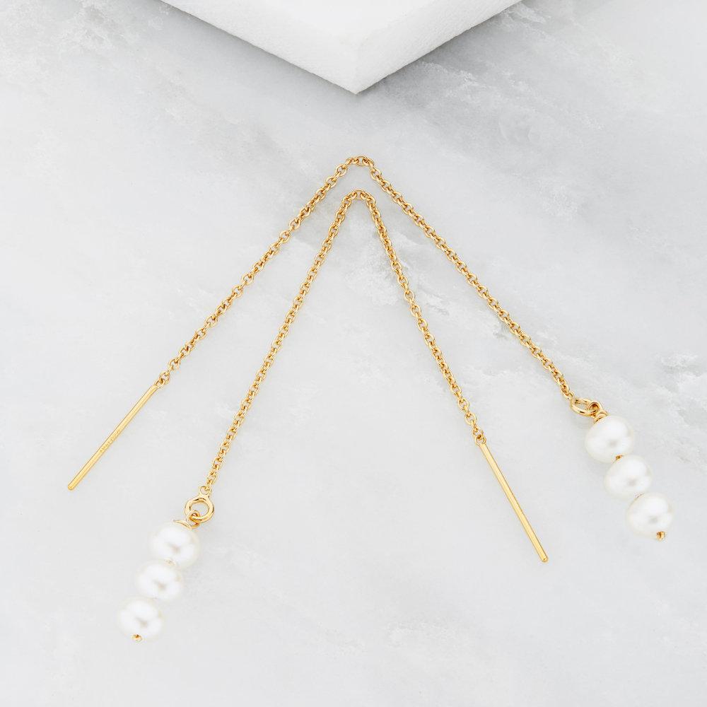 Gold cluster pearl drop ear threaders on a marble surface